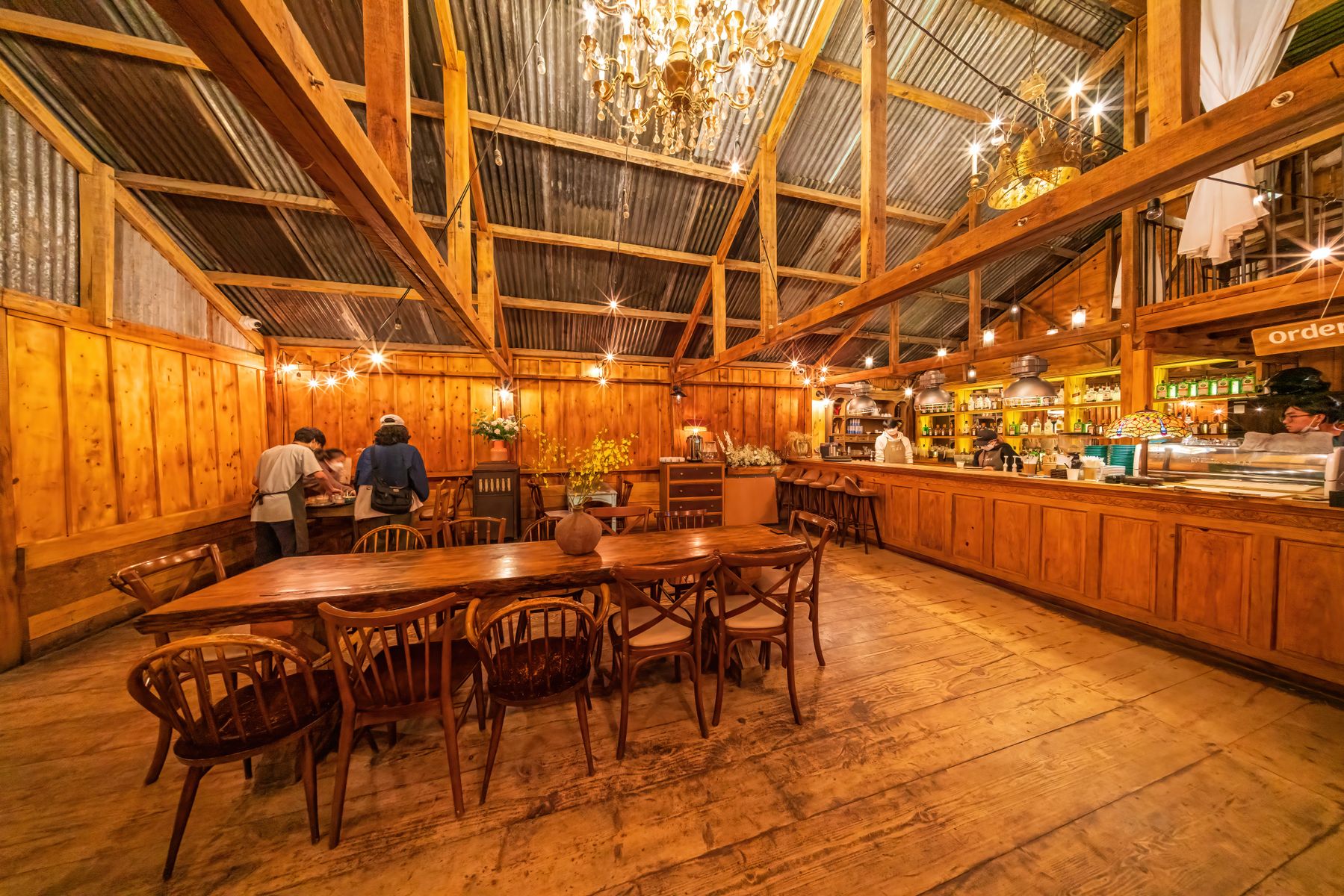 Warmes Café-Interieur mit Holztischen und gemütlicher Beleuchtung